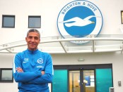 Chris Hughton posing outside the Brighton & Hove Albion offices